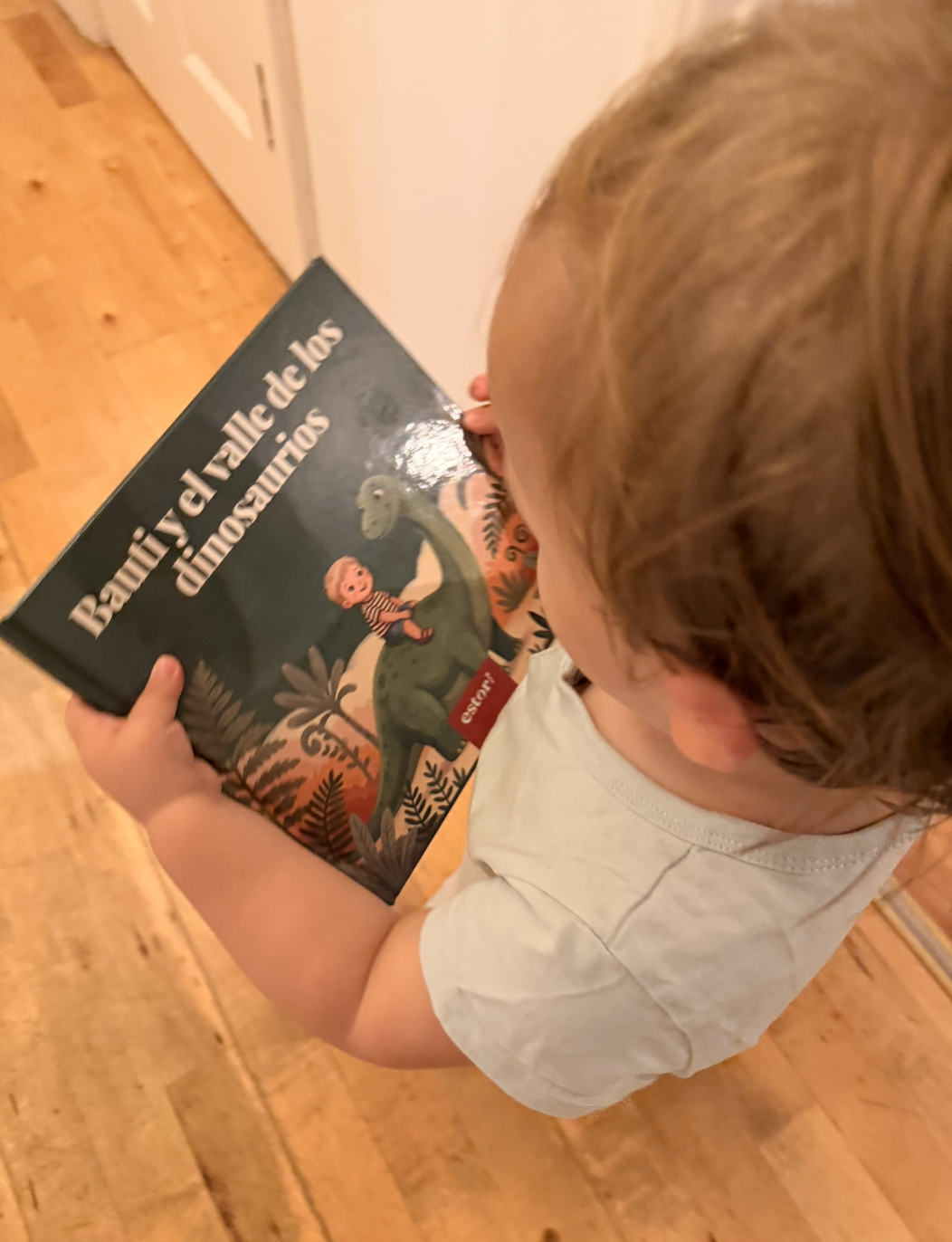 A toddler holding a personalized estori storybook